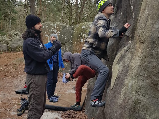 Grimpeur sur bloc en forêt de Fontainebleau, groupe et crash pads en hiver, janvier 2025